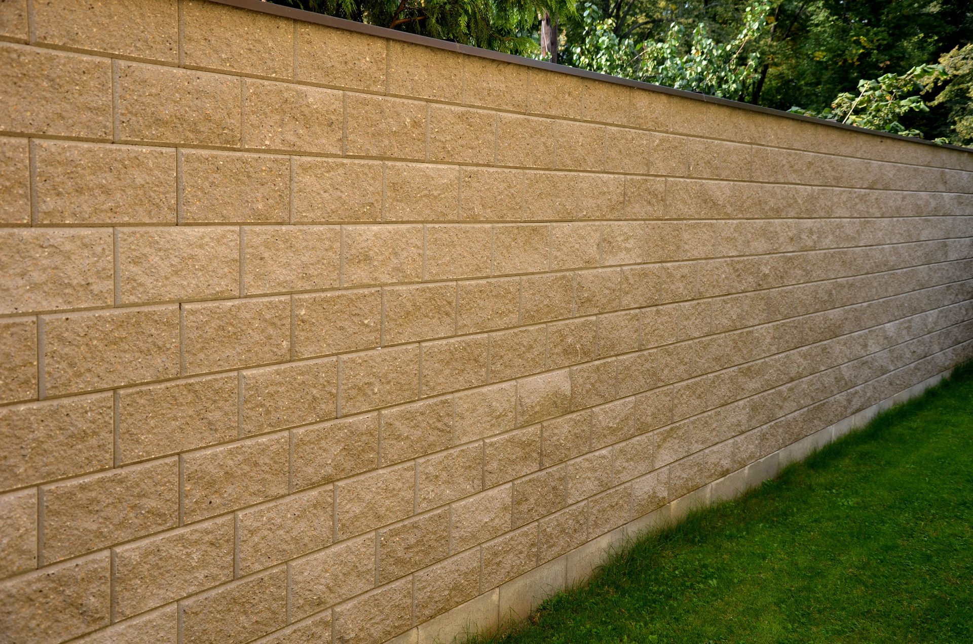 plaster wall fence high made of precast concrete block shed with cement and steel wire with metal roof on top lawn garden park gray beige color rough texture