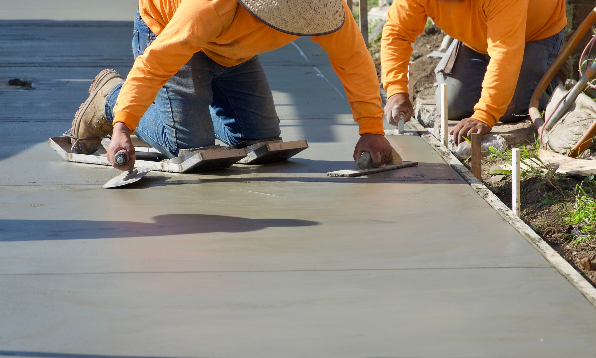 Construction workers putting finishing touch on the freshly poured concrete